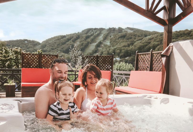 Famille dans les bains à remous avec vue sur la montagne